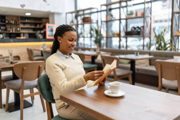 istock Woman in cafe reading a book 2092370365