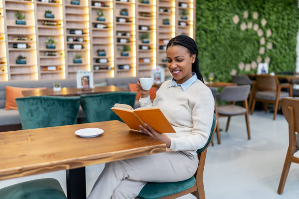 istock Woman in cafe reading a book 2092371911