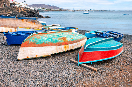 Colorful wooden fishing boats on the beach at the ocean. Fishing village boats
