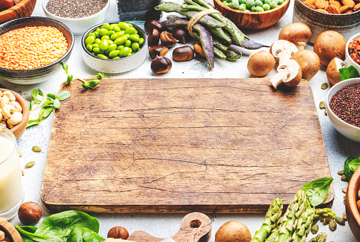 Vegan food background with copy space cutting board. Plant protein., vegetarian nutrition sources. Healthy eating, diet ingredients: legumes, beans, lentils, nuts, soy milk, tofu, cereals, seeds and sprouts. Top view