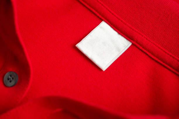 istock Blank white laundry care clothes label on red shirt fabric texture background 2092492666