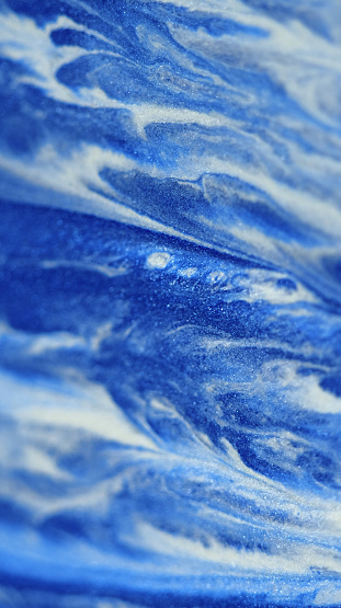 Paint blend. Sea wave foam. Defocused blue white color sparkling glitter texture acrylic ink emulsion flow abstract art background.