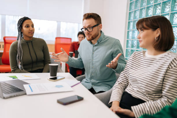 istock Confused diverse male and female colleagues discuss project using laptop computer at workplace. Multiracial coworkers group talking, work together 2092496565