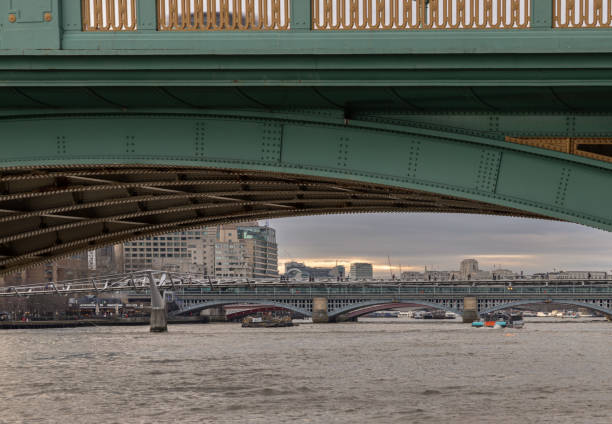 London, UK - Feb 27, 2024 - View of Blackfriars Bridge and Millennium Bridge Looking through underneath Southwark Bridge over The River Thames in London. Space for text, Selective focus.
