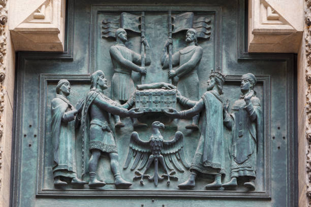 Holy Roman Emperor Charles IV and his wife Anna of Świdnica (Anna Svídnická) presenting the shrine with relics of Saint Vitus to Archbishop Arnošt of Pardubice (Arnošt z Pardubic). Bronze relief by Czech sculptor Otakar Španiel after design by Czech artist Vratislav Hugo Brunner (1926-1929) on the main door of Saint Vitus' Cathedral in Prague Castle in Prague, Czech Republic.