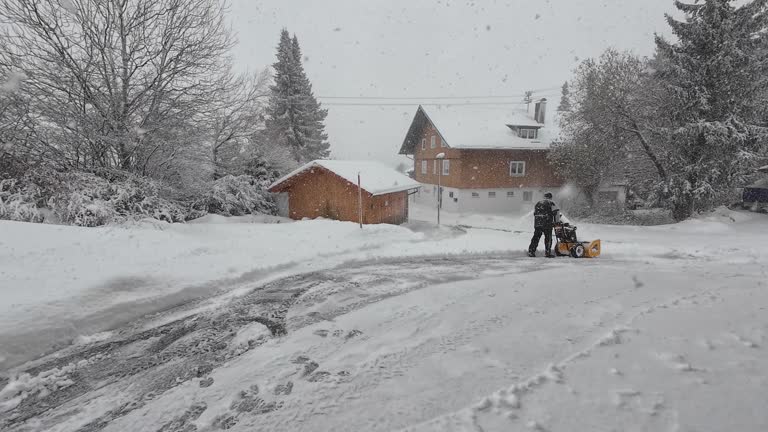 On a winter's day with heavy snowfall, a man is clearing away snow