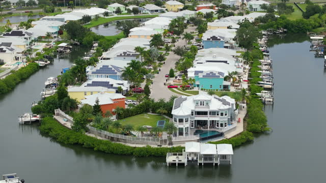 Expensive waterfront houses between green palm trees in southwest Florida. Premium housing development in the USA