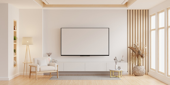 Mockup a white TV with armchair in living room with a white wall- 3D rendering