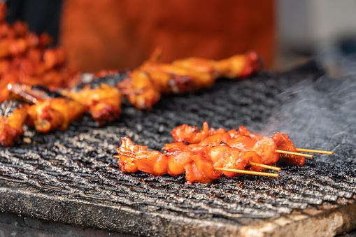 Satays barbeque grilling on the net. It also known as sate, it is a Southeast Asian form of kebab made from seasoned, skewered and barbecued meat, served with a sauce.