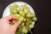 Hand Selecting a Fresh Green Grape