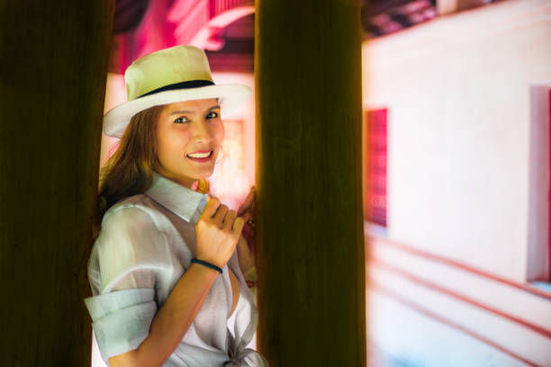 girl with indigenous features standing in the doorway of her house and looking at the camera