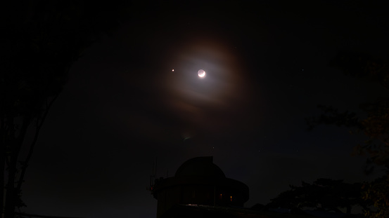 Big super moon over lighthouse in the sea