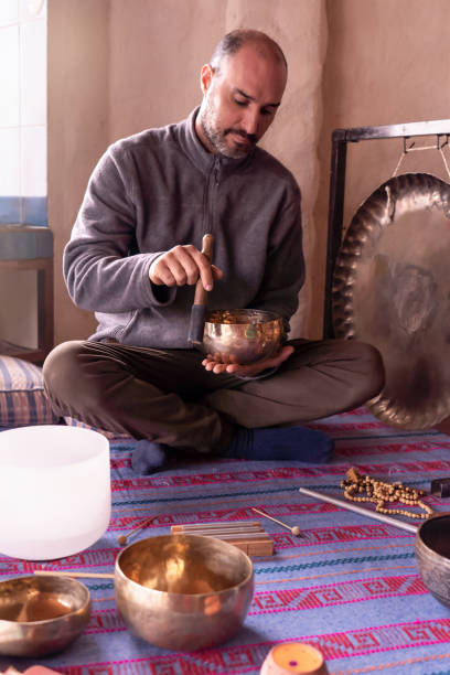 istock Focused Latino man playing a Tibetan singing bowl. 2092870371
