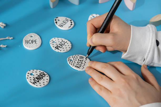 istock Master class writing word RISEN on EASTER clay egg Children air dry clay activity handicraft idea. DIY process step by step instruction. Preparing for Easter holiday decorating. Modern organic design minimalistic plastic free sustainable 2092931649