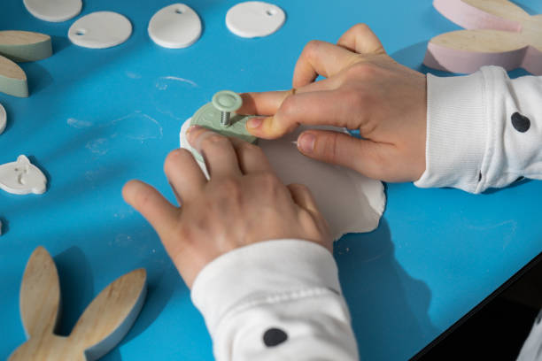 istock Workshop cutting figures Unrecognizable artist do it yourself air dry clay crafts for Easter holiday. Decoration gift idea Handmade children craft. Step by step instruction of painting, pressing figures 2092933727