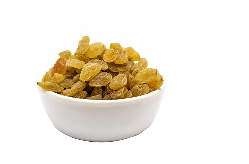 Closeup of Golden Raisin in a White Bowl Isolated on White Background with Copy Space for Texts Writing.