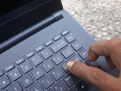 finger hand above laptop keyboard