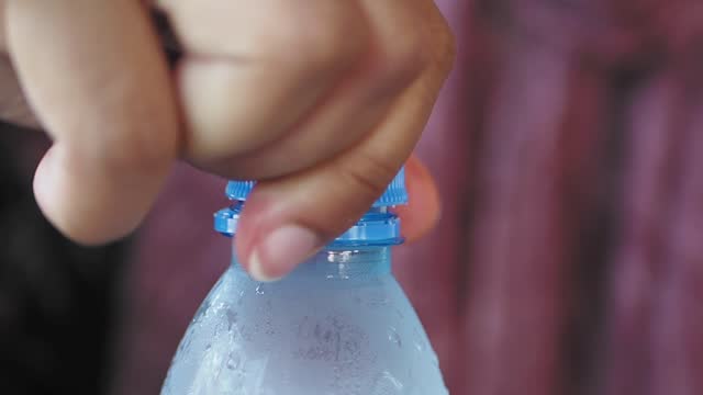 open a cap of a plastic water bottle