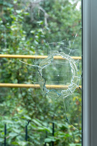 Photo of an accidentally broken kitchen window and attempts to fix it.