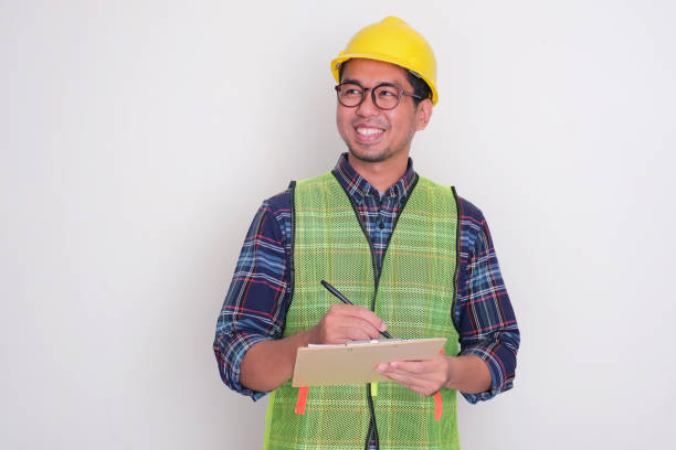 istock A warehouse staff smiling happy while writting stock data report 2093047423
