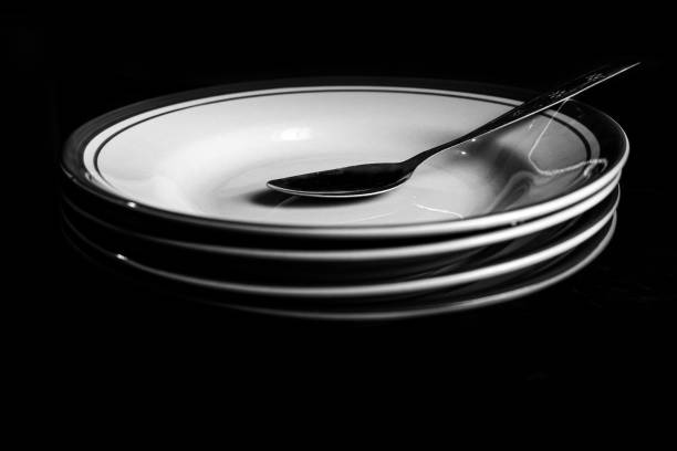 A spoon on a pile of plates in a low light room
