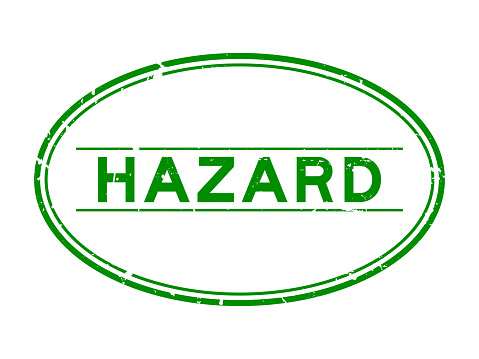 Grunge green hazard word oval rubber seal stamp on white background