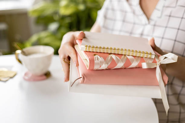 istock Business woman hands holding stack elegant feminine paper diary notepad for planning notes closeup 2093111160