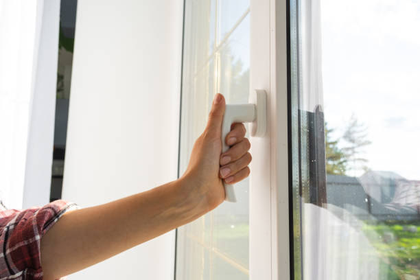 istock The hand holds the handle of a plastic double-glazed window, closing and opening the window with a rotary mechanism, the position of the handle for ventilation, micro-ventilation 2093133457