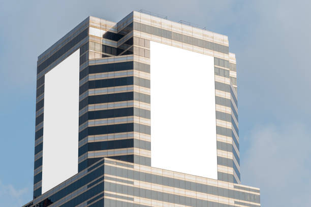 istock Mock up two white vertical LED display billboard on tower building with blue sky background .clipping path for mockup 2093155178
