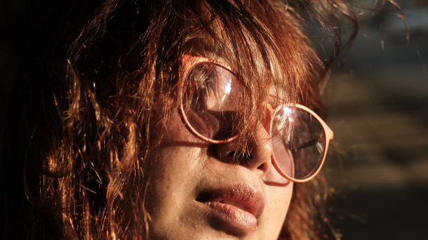 young woman wearing glasses with the afternoon sun