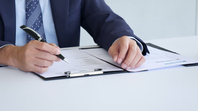 Businessman hands note meeting document in conference room. man Hands writing planning notebook. Close up male hand holding pencil write on diary sketchbook at office desk. Business Planning Concept