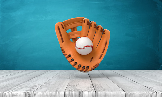 3d rendering of orange baseball glove with a baseball suspended in air above wooden surface near blue wall with copy space. Hobbies and leisure. Active games. American sports.