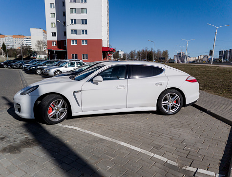 Minsk, Belarus, March 18, 2024 - Side view of white luxury Porsche Panamera Turbo in street parking