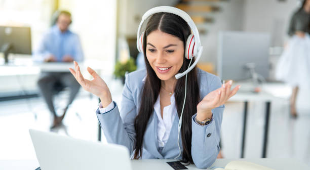 istock Female customer support representative in headset with microphone talking to client in customer support service office. 2093228616
