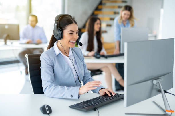 istock Smiling service desk analyst with headset answering client's questions and resolving client's issues in call center. 2093242197