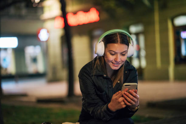 istock A young woman sits on a bench at night. 2093243805
