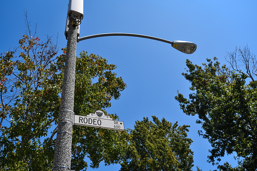 A sign indicating the direction and distance to Rodeo Dr in Beverly Hills, California.