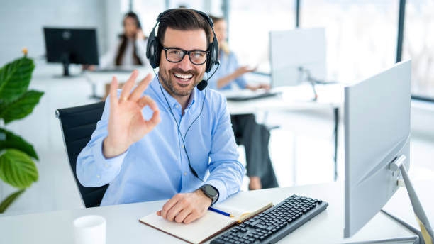 istock Customer service representative showing approval sign to the camera, smiling and gesturing okay at call center office 2093250113