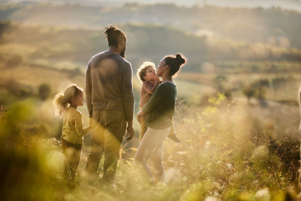 Happy black family talking in autumn day on a hill.
