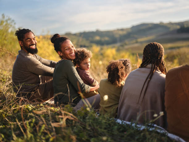 istock Relaxed black extended family talking in grass on a hill. 2093285440
