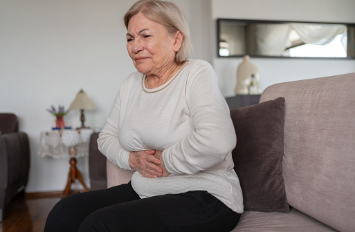 Senior Woman Suffering From Stomachache At Home