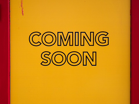 Photography of a sign Coming soon - yellow background and red frames