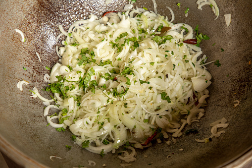 a onion and coriander on a hot vessel