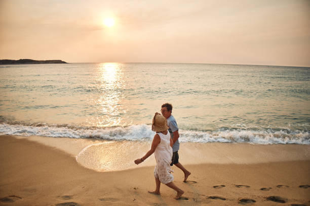 istock Senior couple enjoying walking along the beach 2093347042
