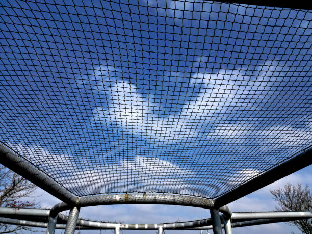 thick tubes welded into a round shape.  pergola with a net serves as a constellation for the climbing vine. The gray design resembles a tennis racketsteel structure for climbing plants, net, circle
