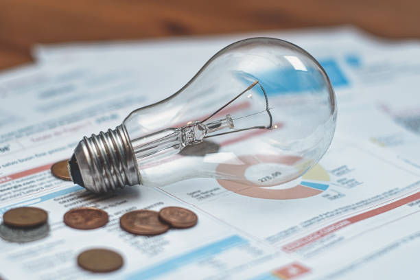 istock Electricity bills with light bulb and coins 2093378257