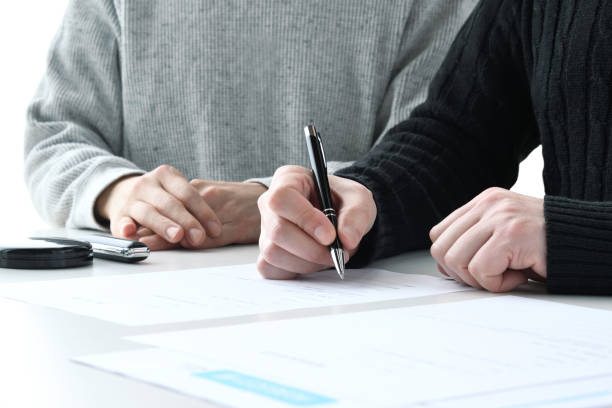 Couple filling out contract sheet with pen