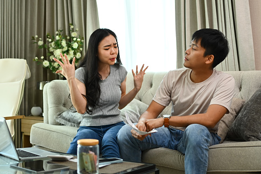 Stressed couple quarreling, arguing about serious financial problems at home.