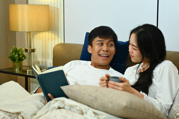 istock Beautiful young couple talking while resting in bedroom together 2093407727