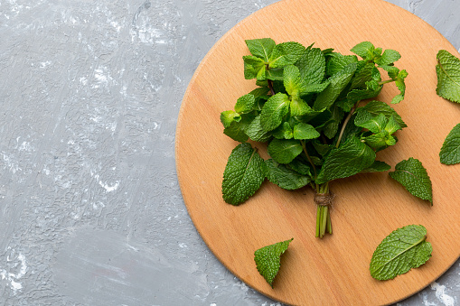 Fresh mint on Cutting board table, top view. Flat lay Space for text.